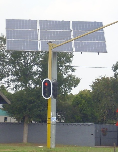 Solar panels powering traffic signals on a fixed pole